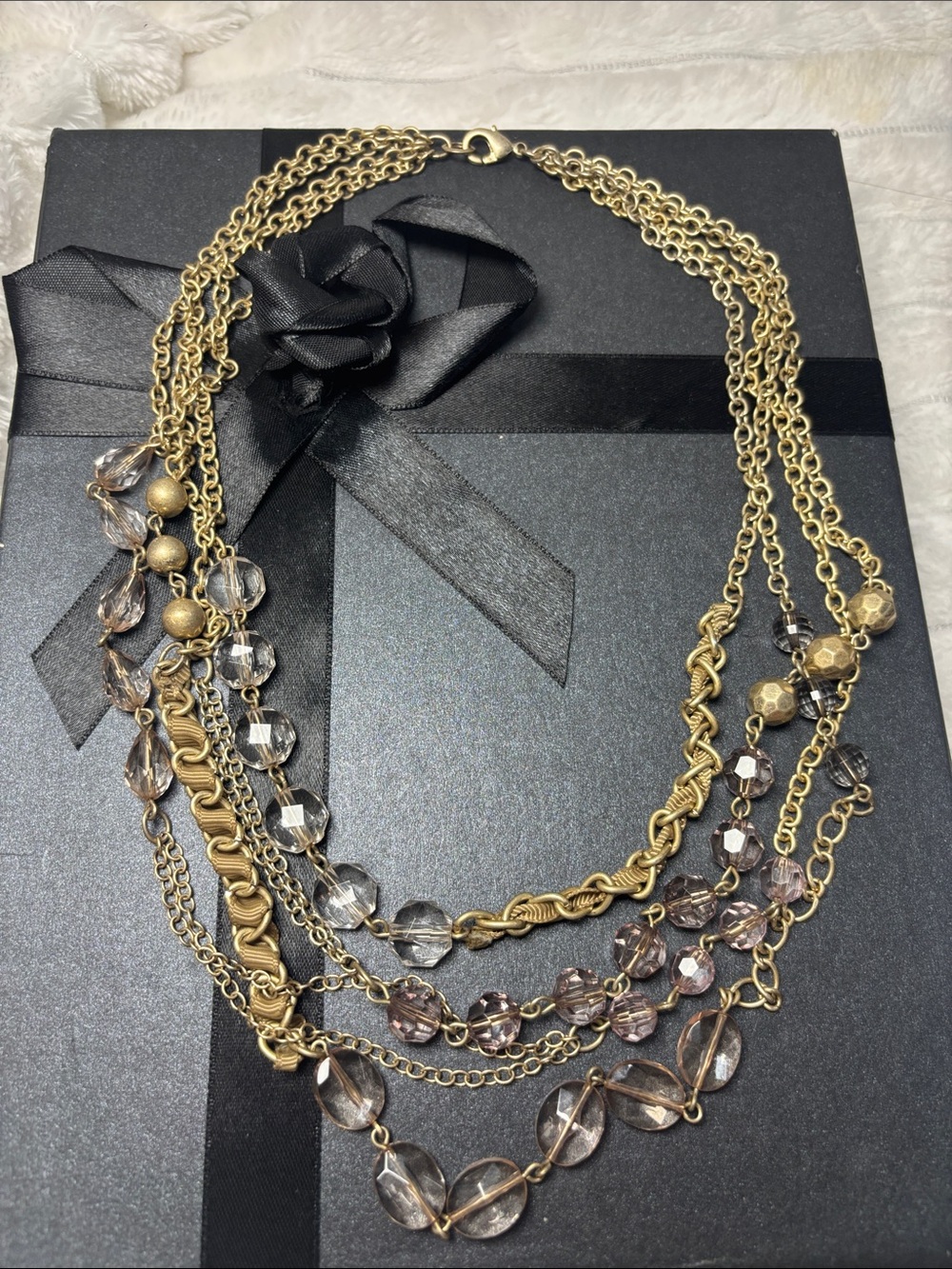 Multi strand  gold-tone necklace featuring light violet and faceted beads